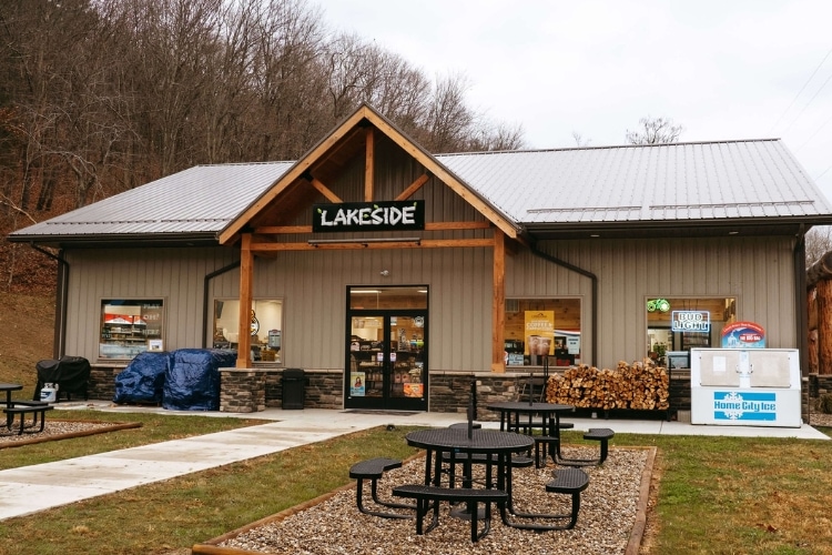 A small store with tables and chairs in the middle of a wooded area near Tappan Lake.