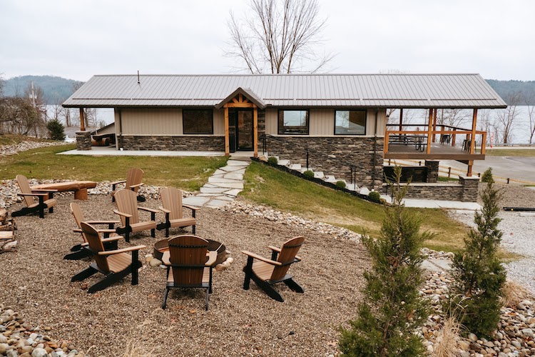 The recreational center at Tappan Lakeside Resort with a patio, chairs, and fire pit in front.